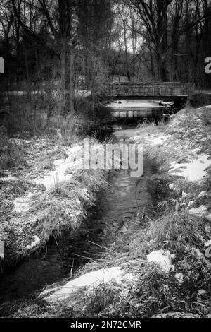 Vor dieser alten Brücke am Francis Creek in der Nähe von Manitowoc, Wisconsin, liegt frischer Schneefall. Stockfoto