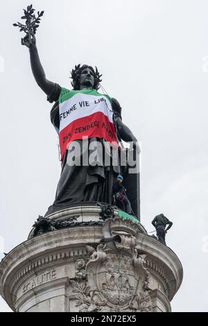 Ein französisch-iranisches Kollektiv organisierte eine Aufklärungskampagne über die Lage der iranischen Frauen in Aufruhr unter dem Ruf der "Freiheitsfrauen". Am Vorabend des Jahrestages der Gründung der Islamischen Republik wurde ein Trikot in drei Sprachen auf dem Statut des Freiheitsplatzes gewebt, in kurdischem "Jin JiyanAzadi", in persischer "Zan Zendegi Azadi" "Freiheitliche Frauen". Die Kordisten wurden schnell von der Polizei auf Mountainbikes erwartet und von vielen Beamten des Pariser Polizeihauptquartiers. Mitglieder der Sicherheitskräfte, Kordisten kletterten auf die Statue, um das Banner zu entfernen. Paris, Frankreich, am 10. Februar 2023. Ph Stockfoto