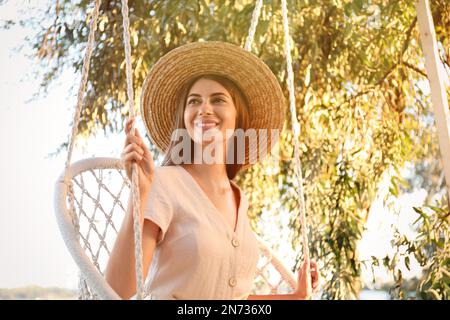 Junge Frau, die sich an sonnigen Tagen im Liegestuhl ausruht. Sommerferien Stockfoto