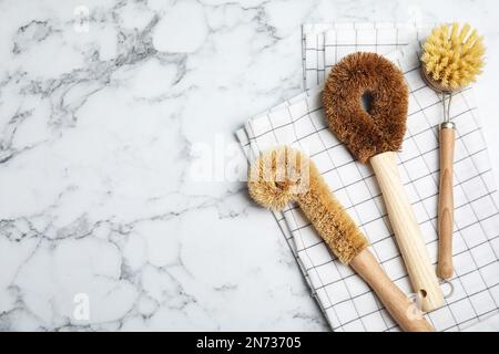 Reinigungsbürsten auf weißem Marmortisch, flach liegend mit Platz für Text. Geschirrspülmittel Stockfoto