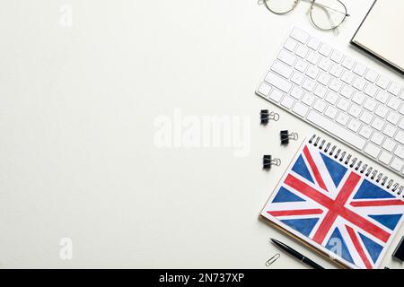 Notizblock, Tastatur und Schreibwaren auf weißem Hintergrund, flach liegend mit Platz für Text. Englisch Lernen Stockfoto