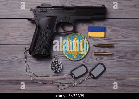 MYKOLAIV, UKRAINE - 19. SEPTEMBER 2020: Flacher Laienaufbau mit ukrainischer Militärausrüstung auf grauem Holztisch Stockfoto