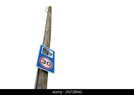 Warnschild für 30 km/h und Radarkamera an einem Telegrafenmast in einem ländlichen Gebiet, das Probleme mit Schnellwagen hat. Stockfoto