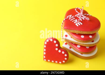 Geschenkset herzförmiger Kekse auf gelbem Hintergrund, Nahaufnahme mit Platz für Text. Valentinstag-Leckerbissen Stockfoto