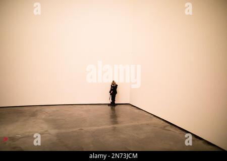 Ein Arbeiter sitzt im Guggenheim Museum in Bilbao, Spanien, an einer Mauer Stockfoto