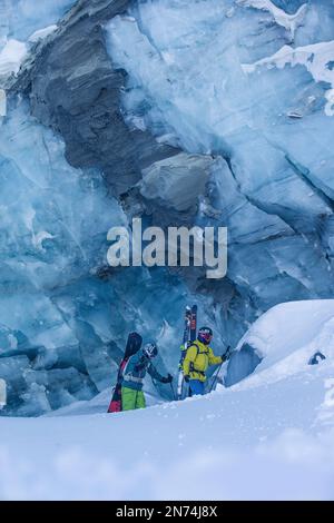 Zwei professionelle Snowboarder und Skifahrer erkunden und fahren eine Gletscherspalte/Eishöhle hoch oben auf dem Pitztal-Gletscher, Pitztal, Tirol, Österreich Stockfoto