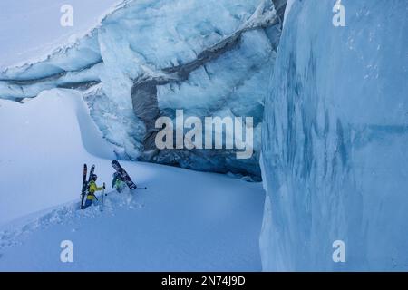 Zwei professionelle Snowboarder und Skifahrer erkunden und fahren eine Gletscherspalte/Eishöhle hoch oben auf dem Pitztal-Gletscher, Pitztal, Tirol, Österreich Stockfoto