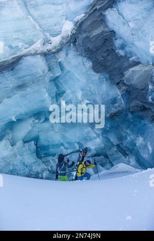 Zwei professionelle Snowboarder und Skifahrer erkunden und fahren eine Gletscherspalte/Eishöhle hoch oben auf dem Pitztal-Gletscher, Pitztal, Tirol, Österreich Stockfoto