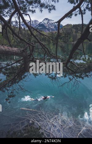 Professioneller Triathlet Schwimmen, Training in einem klaren Bergsee in Allgäu, Alatsee, Bayern, Deutschland Stockfoto