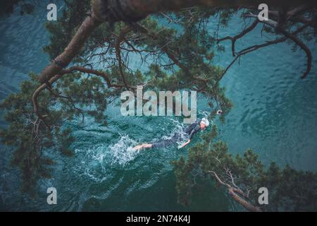Professioneller Triathlet Schwimmen, Training in einem klaren Bergsee in Allgäu, Alatsee, Bayern, Deutschland Stockfoto