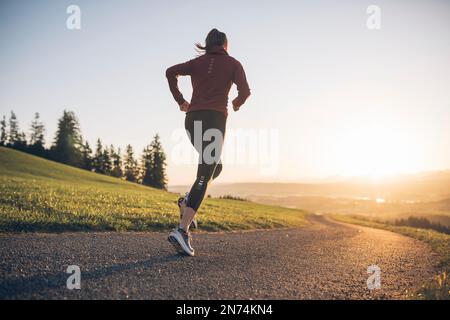 Profitriathleten laufen, Morgenatmosphäre, Sonnenaufgang, Auerberg, Allgäu, Bayern, Deutschland Stockfoto