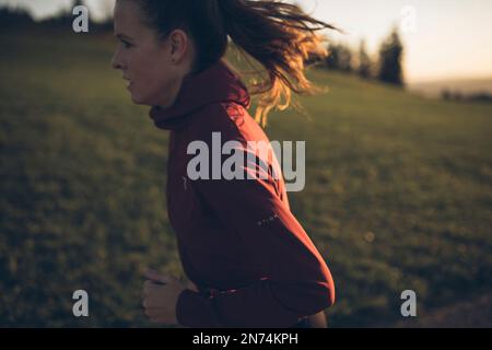 Profitriathleten laufen, Morgenatmosphäre, Sonnenaufgang, Auerberg, Allgäu, Bayern, Deutschland Stockfoto