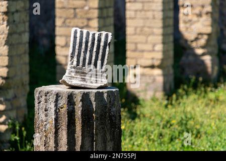 Eine kleine römische Säule, die auf einer größeren Säule liegt, ausgestellt in Pompeji, Süditalien Stockfoto