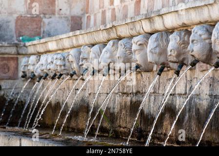 Berühmter mittelalterlicher Brunnen von 99 Ausbrüchen in der Altstadt von L'Aquila, Abruzzi in Italien Stockfoto