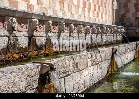 Berühmter mittelalterlicher Brunnen von 99 Ausbrüchen in der Altstadt von L'Aquila, Abruzzi in Italien Stockfoto