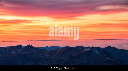 Intensives Sonnenuntergang-Rot über dem Bregenzerwald. Nebel über Oberschwaben. Im Hintergrund Schwarzwald mit Feldberg. Österreich, Deutschland Stockfoto