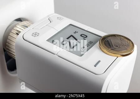 1 Euro-Münze, WLAN-Heizkörperthermostat FRITZ! DECT 302, Display zeigt zwei °C an, Detail, Smart-Home-Technologie, Symbolbild, Vernetzung, digital, Energiekosten, steigende Heizkosten, Stockfoto