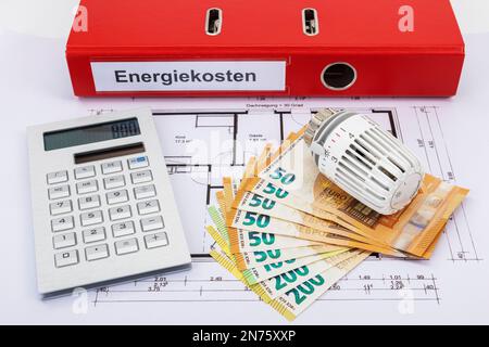 Roter Ordner mit der Bezeichnung Energiekosten, Rechner, Euro-Rechnungen, 800 Euro, Heizkörperthermostat, Legen Sie sich auf die Bauzeichnung, das Symbolbild, das Gebäude, en Stockfoto