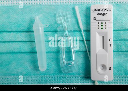 Medizinische Mundnasenschutzmaske, neue Covid-19 Antigen-Schnelltestkassette mit einmal-Tupfer und Röhrchen mit Extraktionslösung, Testsätze, Detail, Stockfoto