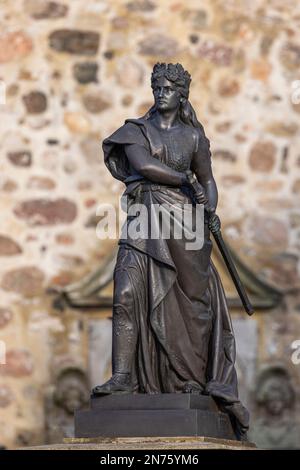 Denkmal, ëGermaniaë-Figur, Kriegsdenkmal des Bildhauers Adolf Jahn, im Hintergrund St. Urbanuskirche in Dorum, Gemeinde Wurster Nordseeö¸ste, Bezirk Cuxhaven, Niedersachsen, Stockfoto