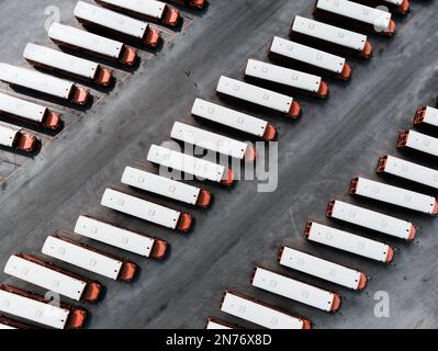 Eine Luftaufnahme von Lkw-Reihen, die auf dem Parkplatz geparkt sind Stockfoto