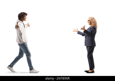 Ein junger afroamerikanischer Mann, der auf eine reife weiße Geschäftsfrau zugeht, isoliert auf weißem Hintergrund Stockfoto