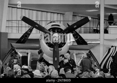 Vor dem nordamerikanischen Texanischen Flugzeug A-6F im Kleiderbügel im American Heritage Museum versammelt sich eine Menschenmenge. Das Bild wurde mit analoger Bla aufgenommen Stockfoto