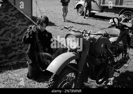 BMW-Motorrad aus dem Zweiten Weltkrieg, das während einer Nachstellung im American Heritage Museum in einem Camp auf einem Feld geparkt wurde. Das Bild wurde in analogem Schwarzweiß aufgenommen Stockfoto