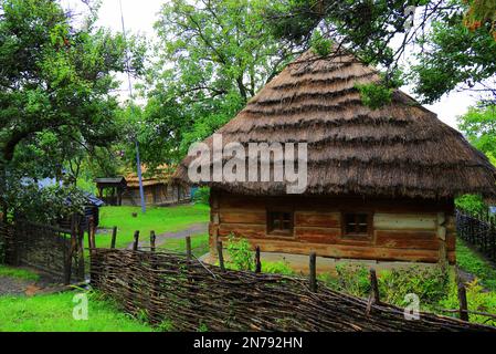 Altes Holzhaus unter Strohdach in der Ukraine. Traditionelles ukrainisches Wohnhaus in ländlicher Umgebung. Uschgorod Ukraine Stockfoto