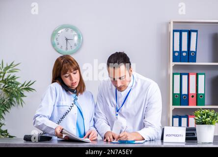 Die beiden Ärzte an der Rezeption im Krankenhaus zu arbeiten Stockfoto