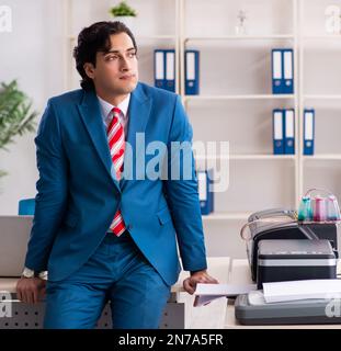 Der junge Arbeitnehmer Kopien beim Kopieren von Maschine Stockfoto