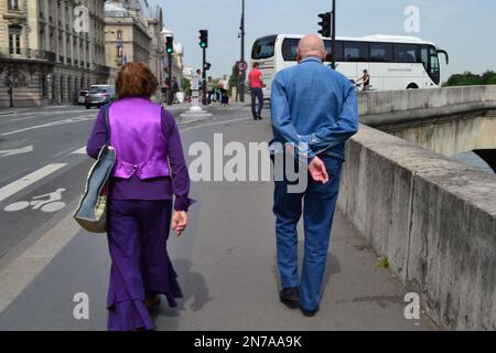 Französisches Paar, das auf einem Fußweg in Paris an der seine spaziert. Stockfoto