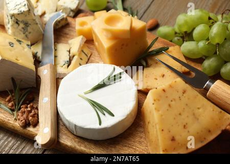 Käseplatte mit Spezialmesser und Gabel auf Holztisch, Nahaufnahme Stockfoto