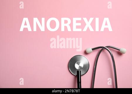 Anorexie-Konzept. Stethoskop auf pinkfarbenem Hintergrund, Draufsicht Stockfoto