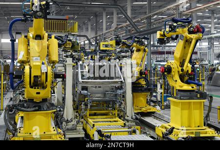 ZOUPING, CHINA - 9. FEBRUAR 2023 - Ein Roboter nietet einen komplett aus Aluminium bestehenden kleinen Logistikkörper an einer Produktionslinie in Weiqiao, die komplett aus Aluminium besteht Stockfoto