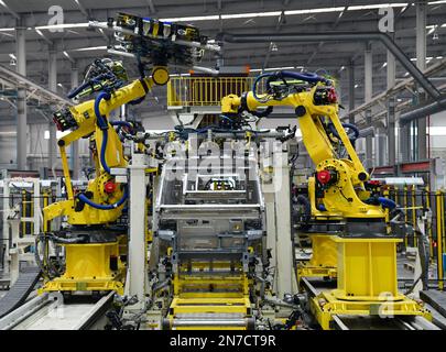 ZOUPING, CHINA - 9. FEBRUAR 2023 - Ein Roboter nietet einen komplett aus Aluminium bestehenden kleinen Logistikkörper an einer Produktionslinie in Weiqiao, die komplett aus Aluminium besteht Stockfoto