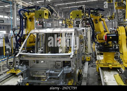 ZOUPING, CHINA - 9. FEBRUAR 2023 - Ein Roboter nietet einen komplett aus Aluminium bestehenden kleinen Logistikkörper an einer Produktionslinie in Weiqiao, die komplett aus Aluminium besteht Stockfoto