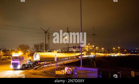 Hamburg, Deutschland. 10. Februar 2023. Ein Schwerlasttransport mit Rotorblättern für eine neue Windturbine ist auf dem Weg von der Autobahnausfahrt Waltershof im Hamburger Hafen zur Kläranlage Dradenau. Drei schwere Lkw brachten am Samstagabend große Teile einer neuen Windturbine nach Hamburg-Waltershof. Nach Angaben des Betreibers der Kläranlage Hamburg Wasser wird die neue Windturbine eine Leistung von 3,6 Megawatt haben und jährlich 9.000 Megawatt-Stunden Strom liefern. Kredit: Christian Charisius/dpa/Alamy Live News Stockfoto