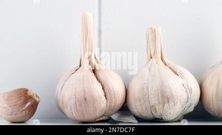 Knoblauchzehen und Zwiebeln auf weißem Hintergrund, Nahaufnahme Stockfoto