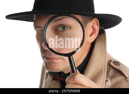 Männlicher Detective, der durch eine Lupe auf weißem Hintergrund schaut Stockfoto