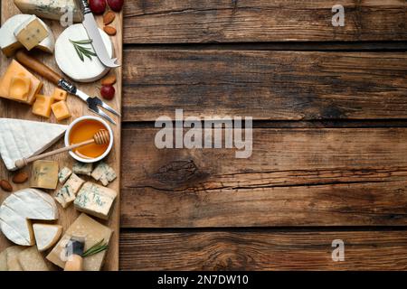 Käseplatte mit Spezialmesser und Gabel auf Holztisch, flach liegend. Platz für Text Stockfoto
