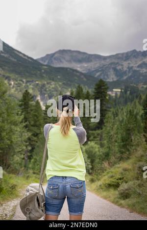 Wunderschöne, blonde, weiße Frau, die draußen im Park ein Selfie mit dem Smartphone macht Stockfoto