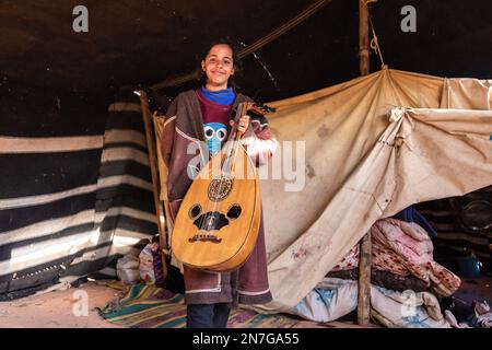 Wadi Rum, Jordanien. 28. Januar 2023. Ein Beduinenmädchen posiert mit einer Gitarre, um in einem Nomadenzelt an der malerischen UNESCO-Weltkulturerbestätte Wadi Rum fotografiert zu werden. Wadi Rum ist bekannt als eine der landschaftlich schönsten Regionen der Welt. (Kreditbild: © Dominika Zarzycka/SOPA Images via ZUMA Press Wire) NUR REDAKTIONELLE VERWENDUNG! Nicht für den kommerziellen GEBRAUCH! Stockfoto