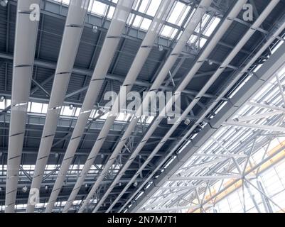 Beleuchtung und Lüftungsanlage in langer Linie an der Decke des Industriegebäudes. Ausstellungshalle. Deckenfabrikbau Stockfoto