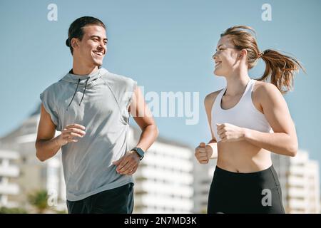 Ein Paar, Fitness und Lächeln, das in Kapstadt gemeinsam für Sport, Training oder Herz-Kreislauf-Training in der Stadt joggt. Glücklicher Läufer, der spaziert Stockfoto