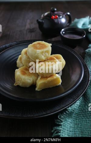 Bakpia-Kuchen gefüllt mit Käse auf einem schwarzen Teller Stockfoto