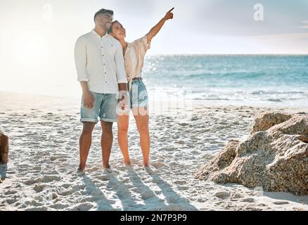 Was ist das da drüben? Ein junges Paar, das Zeit miteinander am Strand verbringt. Stockfoto