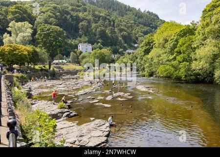 Llangollen Wales united Kingdom Juli 16 2022 , Touristen und Einheimische genießen Paddeln und Sonnenbaden auf dem Fluss de Llangollen wales Stockfoto