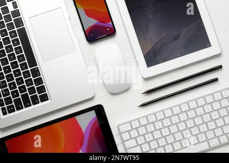 MYKOLAIV, UKRAINE - 28. AUGUST 2020: Flacher Laienaufbau mit iPhone 11, MacBook Laptop und iPad Tablets auf weißem Tisch Stockfoto