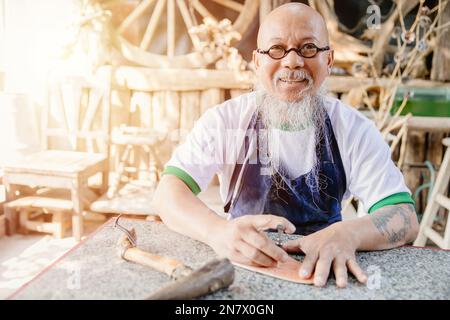 Porträt fröhlicher Ledermacher Handwerker in eigener Werkstatt kleines Studio hergestellt auf Bestellung Meisterwerk Stockfoto